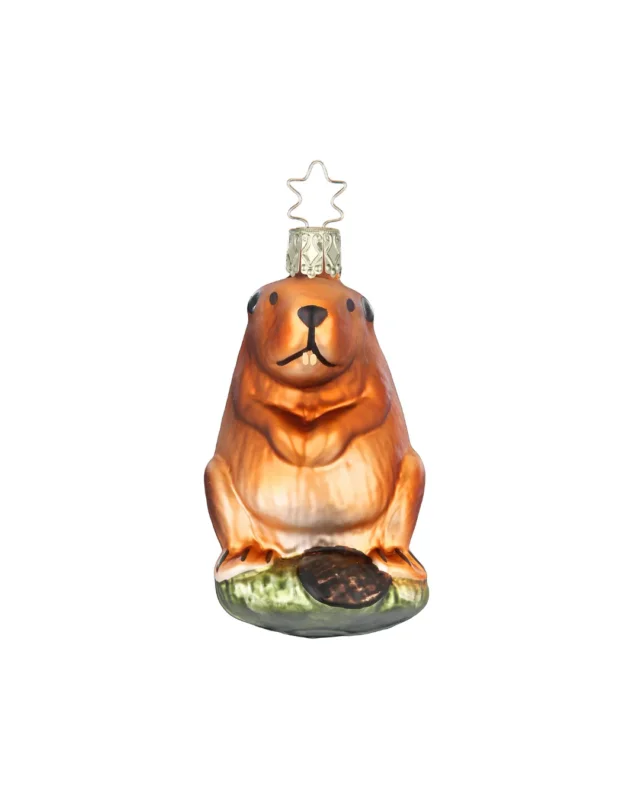 Biber Weihnachtsbaumschmuck von Inge Glas handgefertigt in Deutschland. Der Biber sitzt auf einem grünen Stein und schaut neugierig. Sein Fell ist orange-bräunlich und sein Schwanz dunkelbraun.