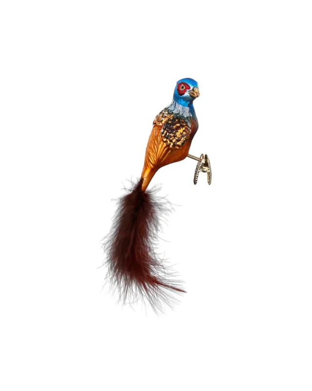 Farbenfroher Fasan Weihnachtsbaumschmuck zum Klemmen. Der Fasan trägt eine echte braune Feder als Schwanz, hat einen orange-braunen Körper mit glitzernden Highlights an den Flügeln und einen blauen Kopf mit rot-brauner Augenumrandung.
