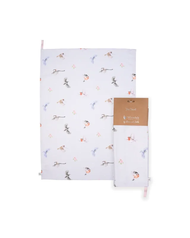 Komplettansicht des Geschirrtuchs mit dem Vogel-Motiv von Wrendale Designs. Leicht davor auch die verpackte Variante und beides vor weißem Hintergrund.