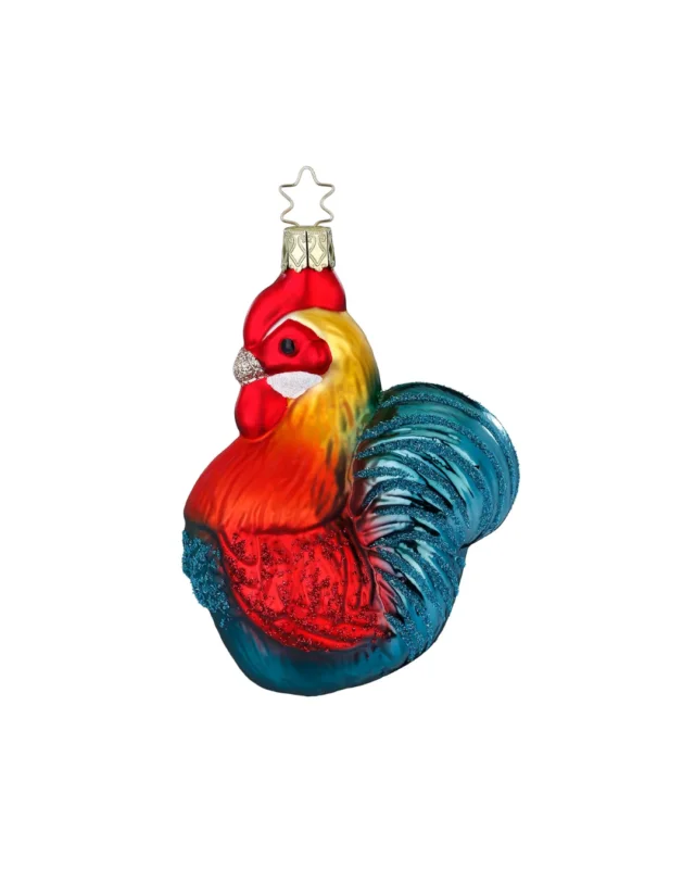 Farbenfroher Hahn Weihnachtsbaumschmuck von Inge Glas handgefertigt in Deutschland. Der Hahn hat blaue Schwanz und Burstfedern, rote Flügel und einen gelb-grünen Nacken. Sein Schnabel ist silbern mit Glitzer.