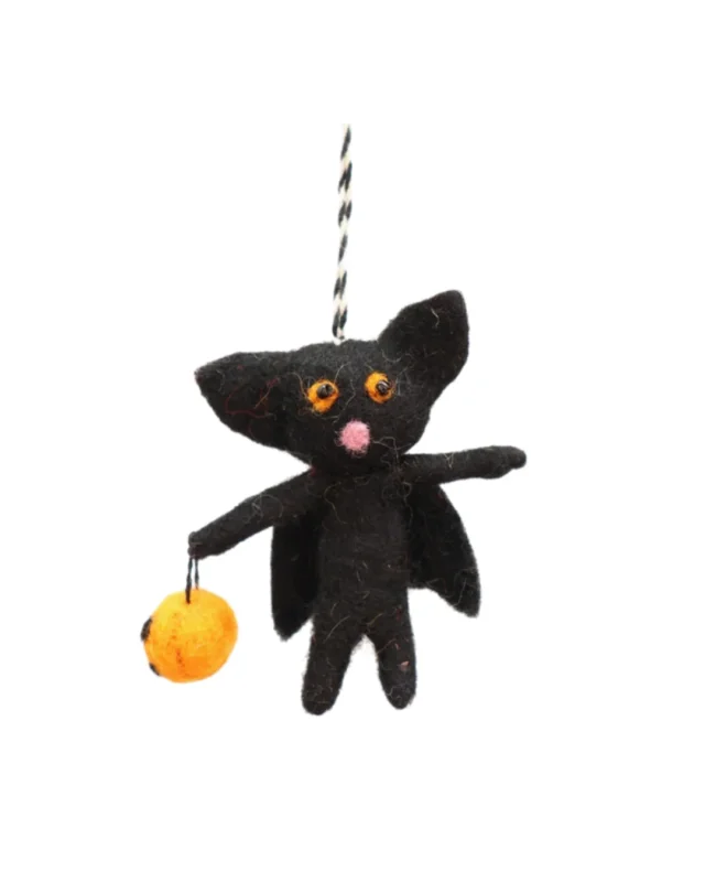 Halloween Fledermaus Filzanhänger "Tricky" von Grace und Gloria aus schwarzem Filz mit orangefarbenen Augen und oranger Kürbislaterne in der Hand.