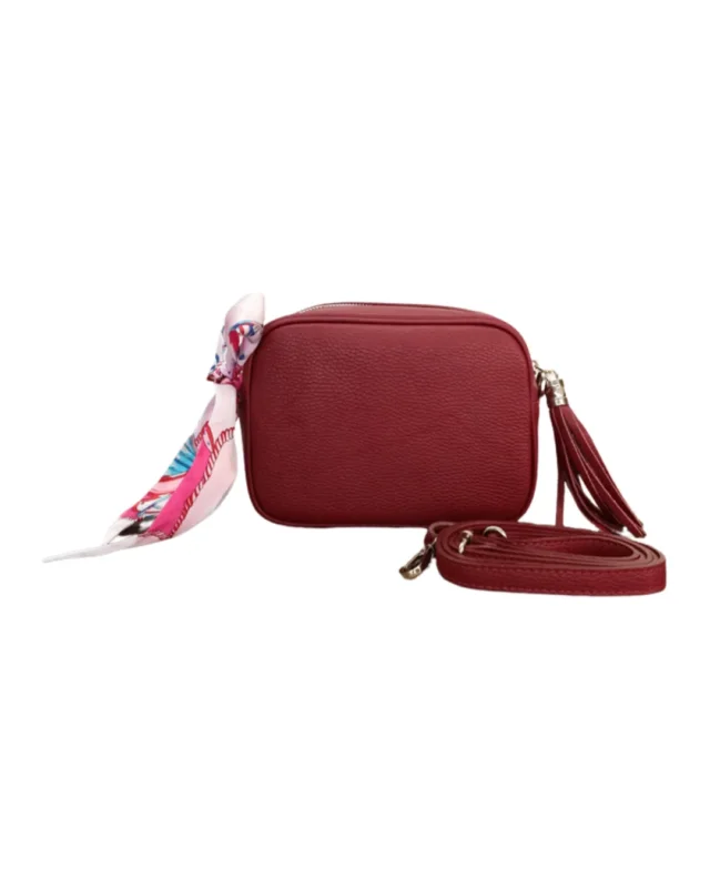 Vollansicht der burgunder Ledertasche "Isolde" von Südstrand mit silbernen Verschluss vor weißen Hintergurnd. Das Bandana ist abstrakt gestaltet und ist größtenteils pink/weiß.