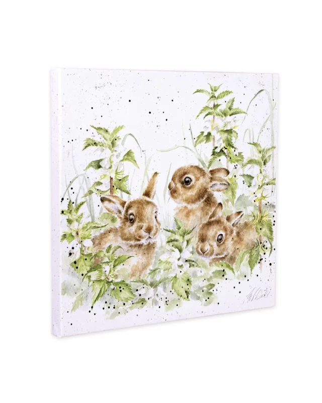 Illustration von drei jungen Hasen zwischen grünen Pflanzen und Frühlingsblüten auf einer quadratischen Leinwand von Wrendale Designs.