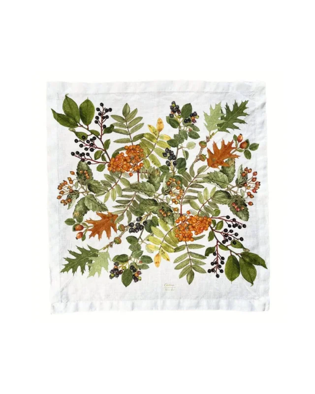 Herbst Leinen Stoffserviette "Autumn" von Koustrup & co vor weißen Hintergrund. Die Serviette ist Weiß. Das Motiv zeigt verschiedenen Herbstgeäst.