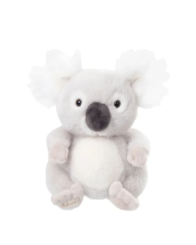 Ein cremefarbener Baby Koala von Bukowski sitzt aufrecht auf einem weißen Hintergrund. Das Kuscheltier hat große, schwarze Augen und flauschige Ohren.