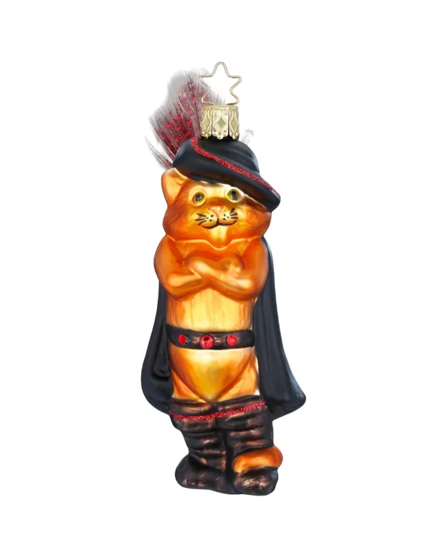 "Gestiefelter Kater" Ornament mit orangem Fell, verschränkten Armen, schwarzen Stiefeln, schwarzem Hut und schwarzem Gürtel. Mit roten Details wie Punkten und roten Federn und Ziernähten.
