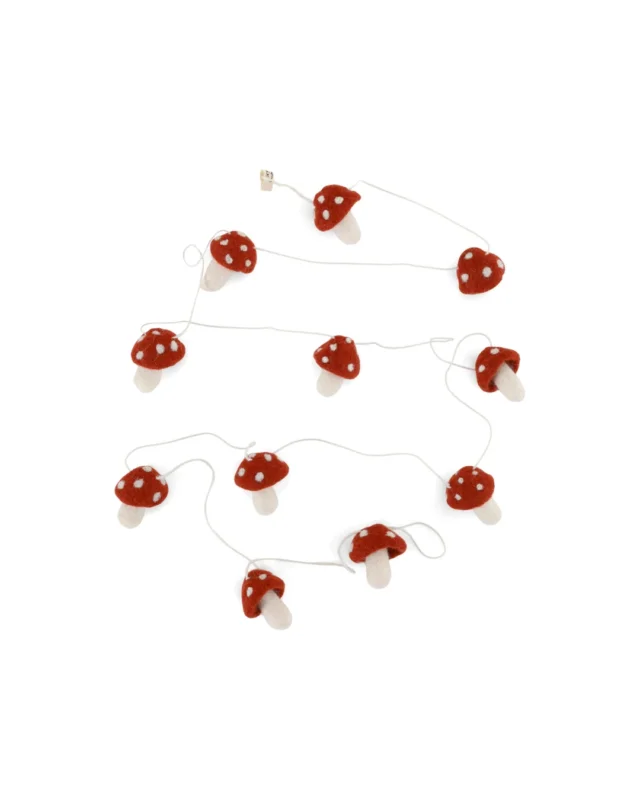 Handgefertigte Filz Girlande von Gry & Sif mit Fliegenpilzen für Weihnachtsbaum oder Äste vor weißem Hintergrund.