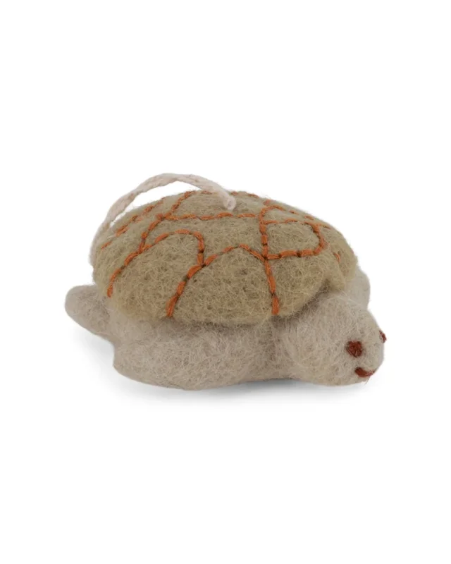 Filzanhänger in Form einer beige-grünlichen Schildkröte von Gry & Sif vor weißem Hintergrund.