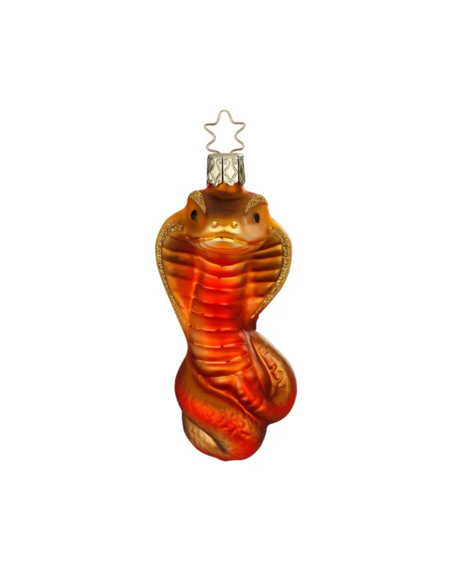 Der in Deutschland handgefertigte Weihnachtsbaumschmuck "Schlange" zeigt eine rot-orange-goldene Kobra, welche Augen- und Seitenpartien mit Glitzer verziert hat.
