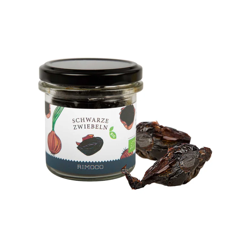 Bio Schwarze Zwiebeln fermentiertes Glas und zwei schwarze fermentierte Zwiebeln auf weißem Hintergrund.
