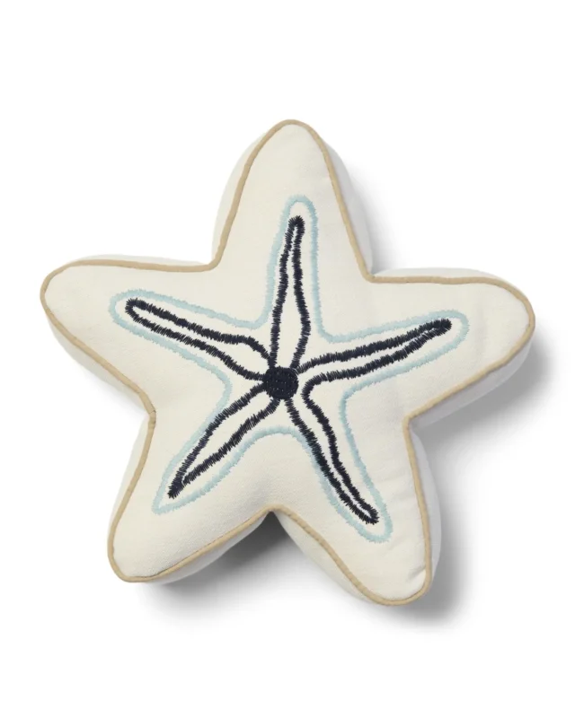 Seestern Kissen "Starfish Box Pillow" von Riviera Maison vor weißen Hintergrund. Das Kissen ist wie ein Seestern geformt und größtenteils Weiß mit schwarz/blauen Details.