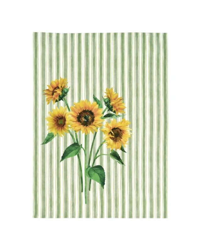 Sonnenblumen Geschirrtuch „Sun Kitchen“ von Sander mit drei großen Sonnenblumen auf grün-weiß gestreiftem Grund. Das Tuch hängt auf weißem Hintergrund und zeigt das detailreiche Motiv.