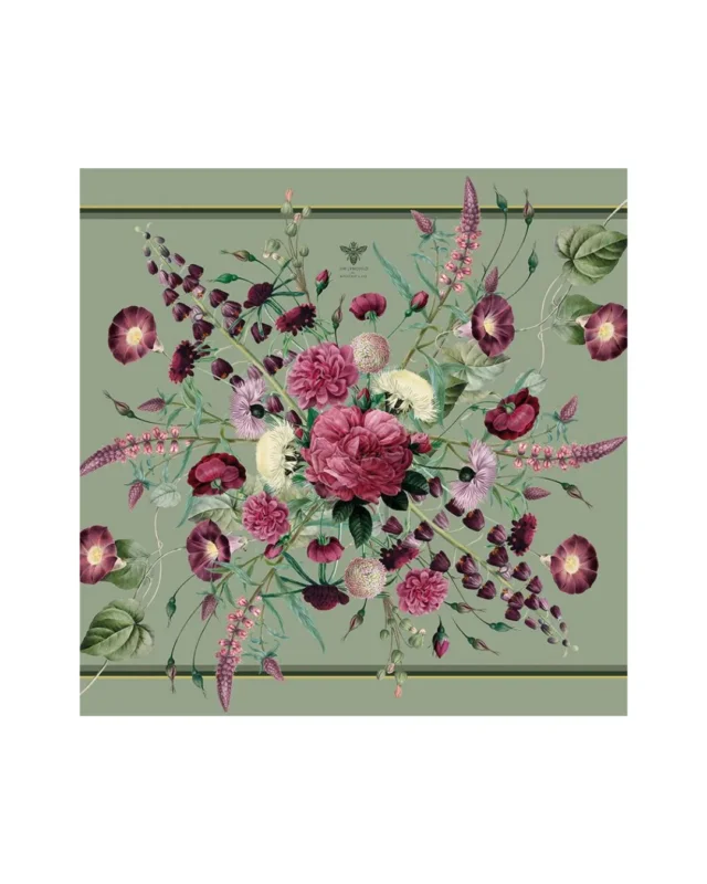 Eine nah aufgelegte, teilweise gefaltete Leinenserviette Blossom Garden von Koustrup & Co. auf weißem Hintergrund. Die Serviette zeigt zarte rosa und grüne Blumenmuster auf naturfarbenem Leinen.