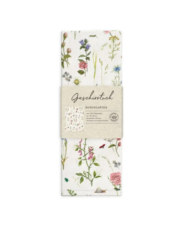 Noch verpacktes Geschirrtuch "Rosengarten" auf weißen Hintergrund. In dem Motiv sind viele Blumen und florale Merkmale zu sehen.