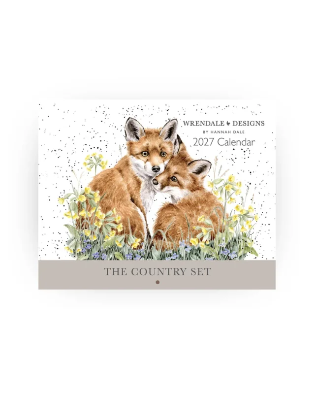 Wandkalender 2027 "The Country Set" von Wrendale Designs vor weißen Hintergrund. Das Motiv besteht aus 2 Füchsen welcher in einer Blumenwiese kuscheln.