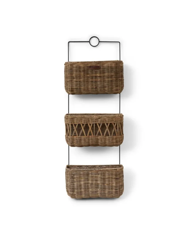 Wandregal "Rustic Rattan Wall Rack" von Riviera Maison. Das Wandregal hängt an einer weißen Wand und besteht aus 3 Etagen mit verschiedenen Designs.