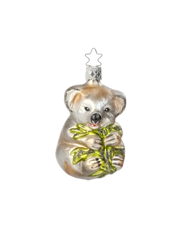 Der niedliche handgefertigte Koala Weihnachtsbaumschmuck von Inge Glas. Der Braun-weiße Koala hat einen Eukalyptus Zweig in den Pfoten. Ohren und Zweig sind mit Glitzer verziert.