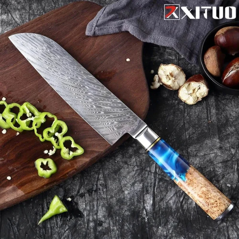 Santoku Küchenmesser mit Damastklinge und blauem Harzgriff auf Holzbrett mit geschnittener Paprika