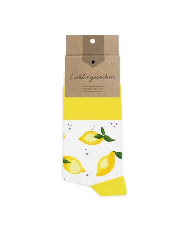 Lieblingssocken "Fresh Lemons" aus Baumwolle vom Grätz Verlag vor weißen Hintergrund. Das Motiv besteht aus vielen Zitronen und verschiedenen Zitronen-Feen,welche auf und vor den Zitrusfrüchten sitzen. Die Illustration stammt von Silke Leffler.