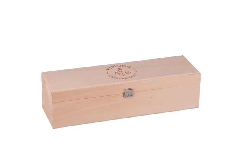Holzbox mit Metallverschluss und Logo, geöffnet und bereit zum Befüllen, ohne sichtbaren Inhalt.
